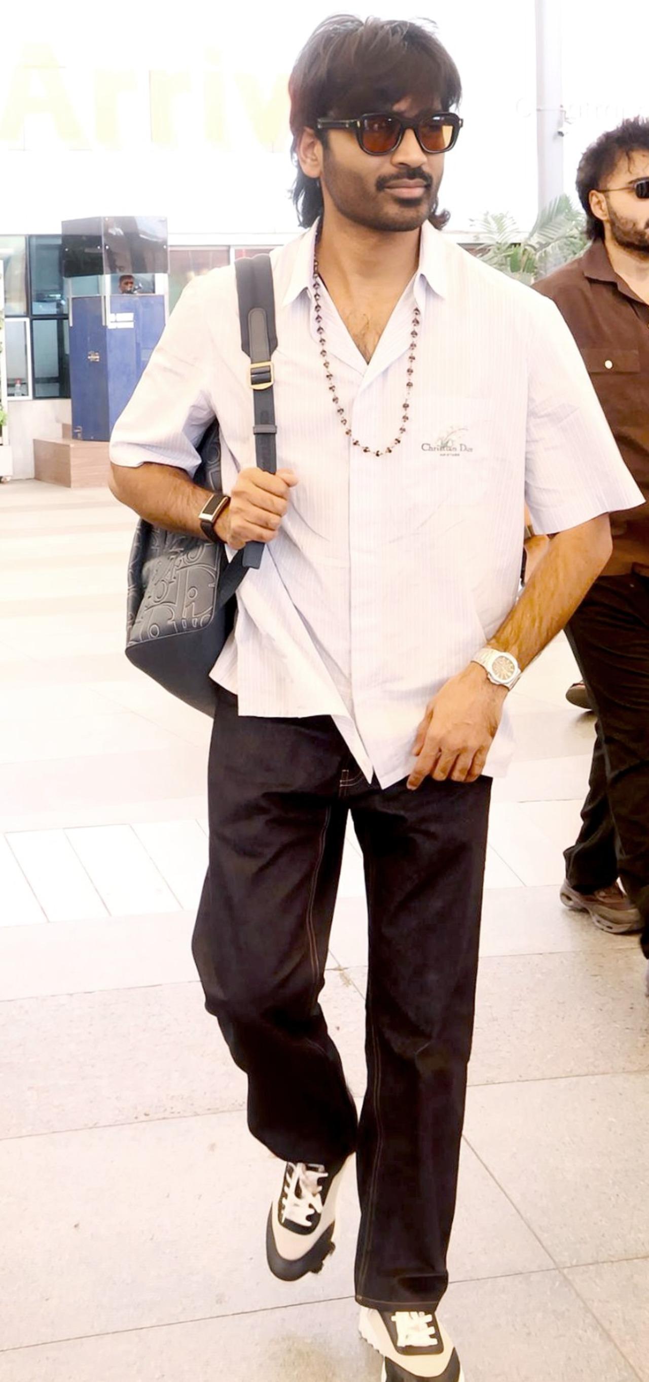 Dhanush was spotted arriving in the city as he was papped at the airport in a while shirt and black pants.